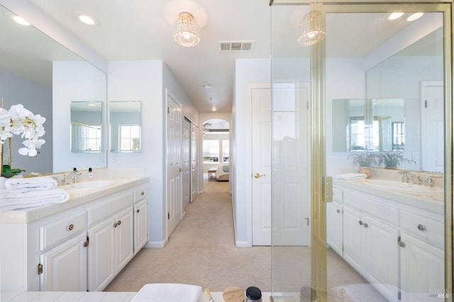 bathroom featuring two vanities, recessed lighting, visible vents, and a sink