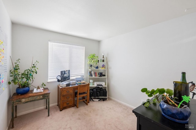 home office with baseboards and light carpet