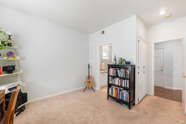 sitting room with visible vents, light colored carpet, and baseboards