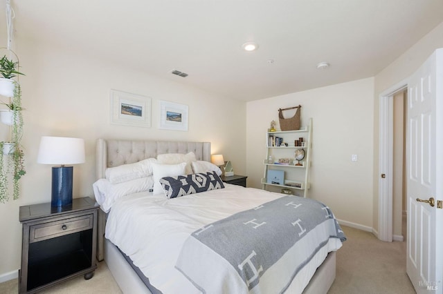 bedroom featuring visible vents, light colored carpet, and baseboards