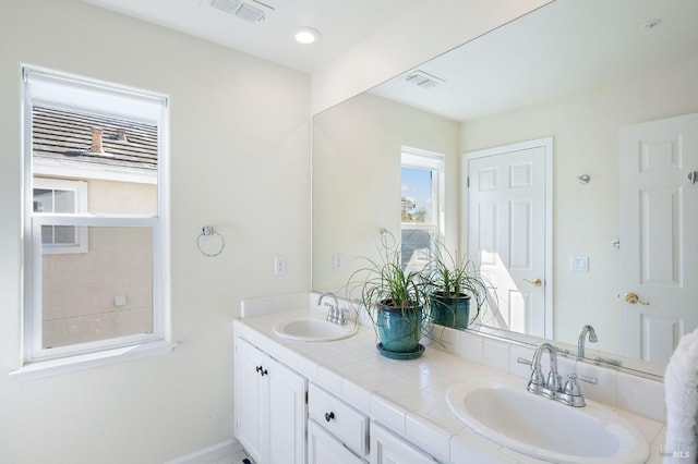 full bathroom featuring double vanity, visible vents, and a sink