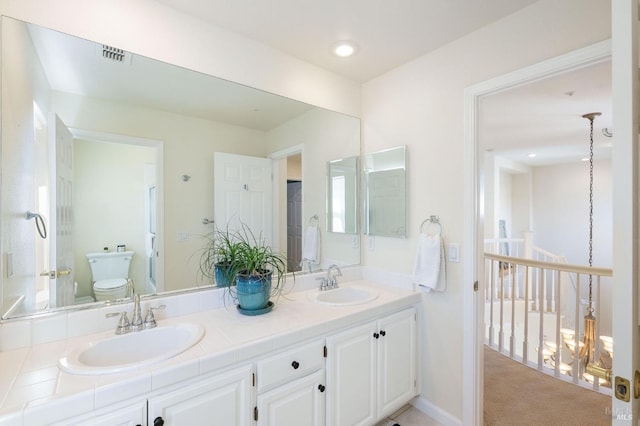 full bathroom featuring double vanity, visible vents, toilet, and a sink