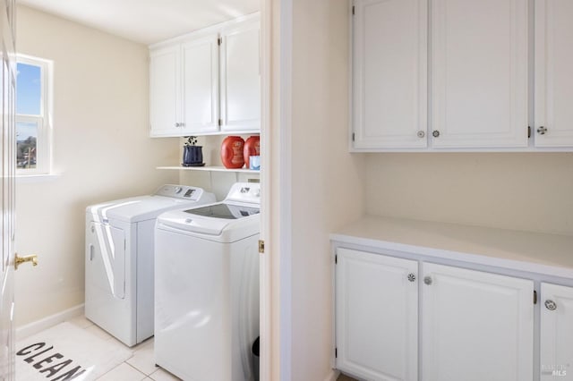 laundry area with light tile patterned floors, cabinet space, and washing machine and dryer