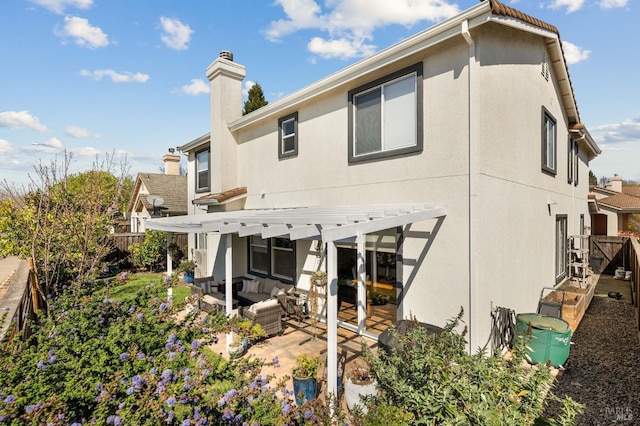 rear view of property featuring a pergola, a patio, fence, an outdoor hangout area, and a chimney