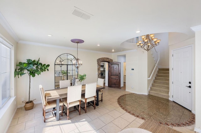 dining room featuring a chandelier, stairway, arched walkways, and visible vents