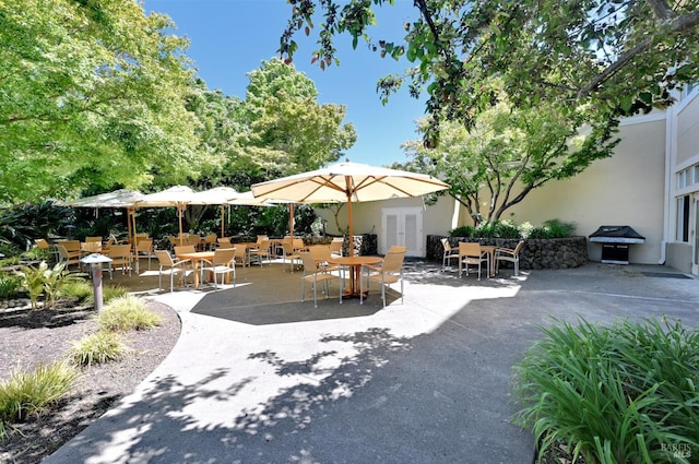 view of patio featuring outdoor dining area, area for grilling, and french doors