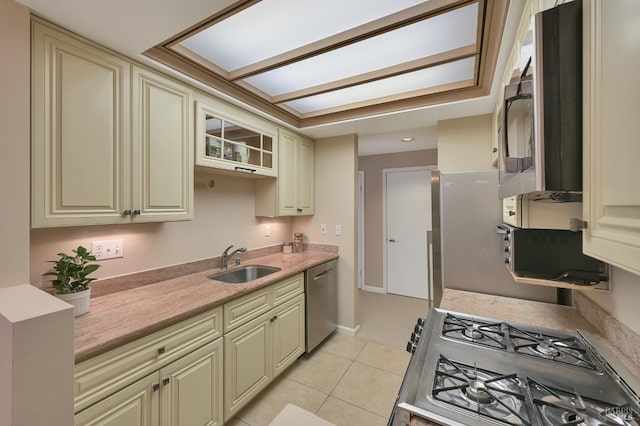 kitchen with a sink, gas stove, cream cabinetry, and dishwasher