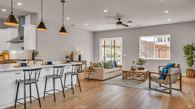 living room with visible vents, recessed lighting, a ceiling fan, and light wood-style floors