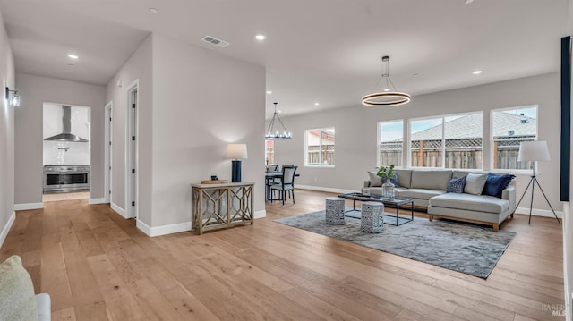 living room with visible vents, recessed lighting, and light wood-style floors