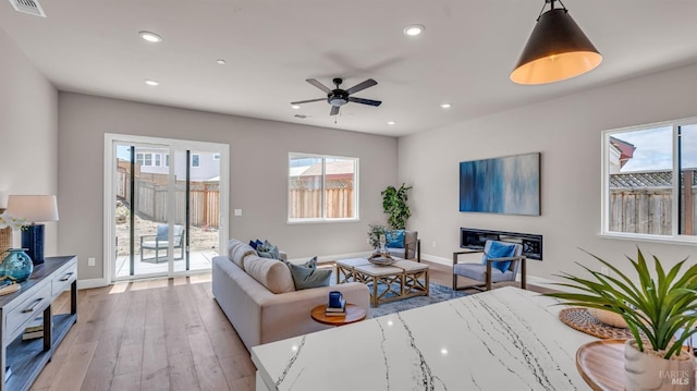 living room featuring a ceiling fan, wood finished floors, visible vents, baseboards, and recessed lighting