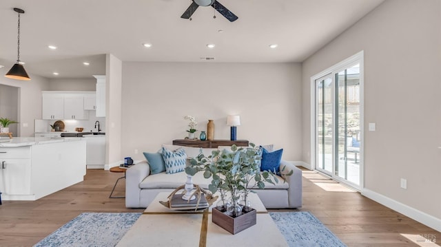 living area with recessed lighting, light wood-style flooring, and ceiling fan