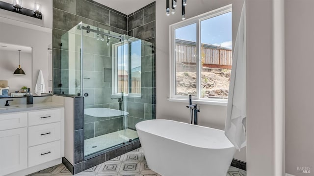 bathroom featuring a wealth of natural light, a freestanding tub, vanity, and a shower stall