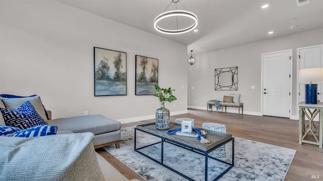 living room with wood finished floors, visible vents, baseboards, lofted ceiling, and recessed lighting