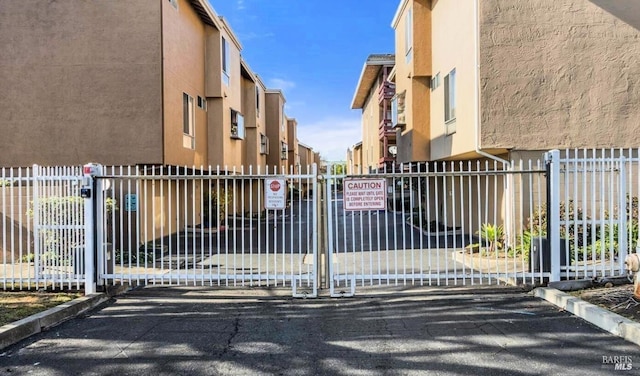 view of gate featuring fence and a residential view
