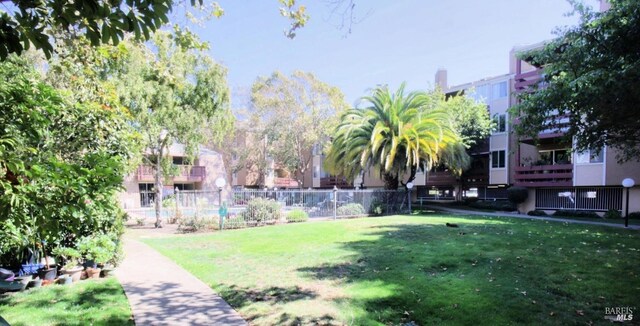 view of property's community featuring fence and a lawn