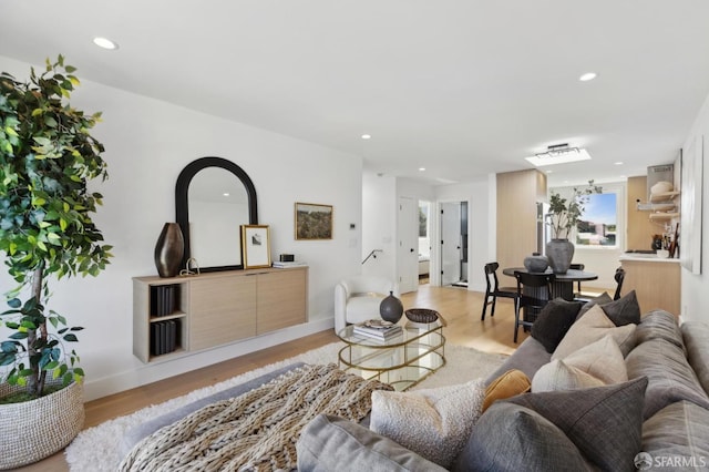 living room featuring light wood-style flooring, recessed lighting, and baseboards