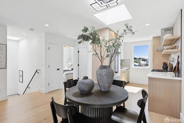 dining space featuring recessed lighting, a skylight, light wood-type flooring, and baseboards