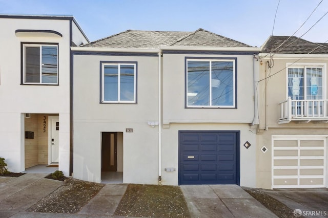 multi unit property with stucco siding and a shingled roof