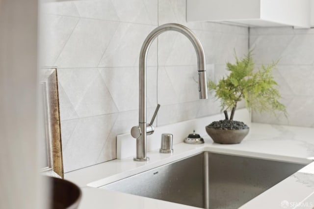 details with decorative backsplash, light countertops, and a sink