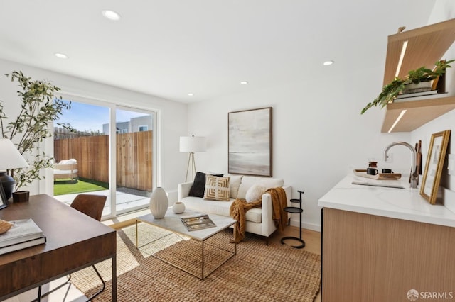 living area featuring recessed lighting, baseboards, and light wood-style floors