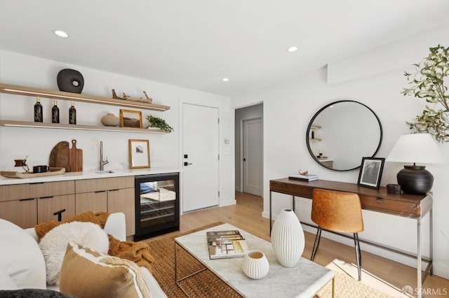 living room with beverage cooler, recessed lighting, indoor wet bar, and light wood-style floors