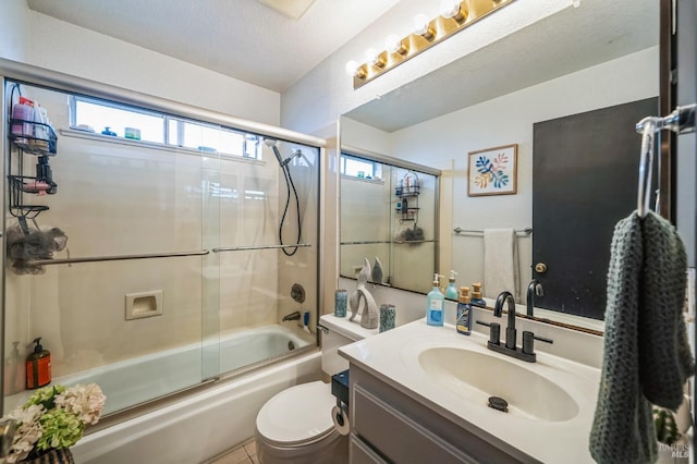 bathroom with enclosed tub / shower combo, toilet, vanity, and a textured ceiling