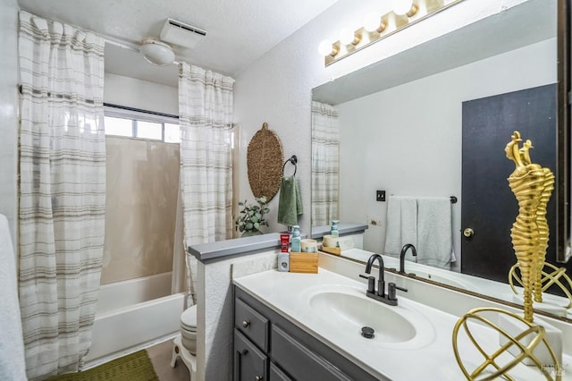 full bath featuring vanity, shower / bath combo with shower curtain, a textured ceiling, toilet, and a textured wall