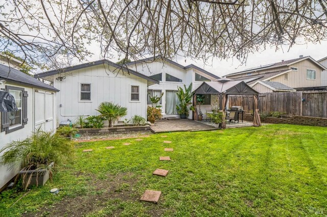 rear view of house with a patio area, a yard, and fence