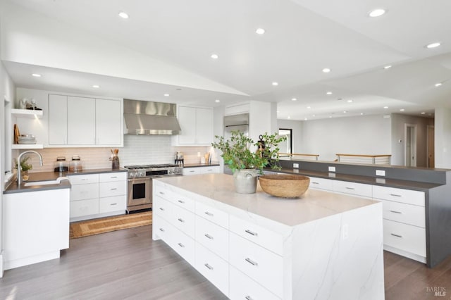 kitchen featuring open shelves, wall chimney range hood, double oven range, modern cabinets, and a sink