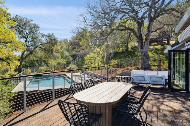 wooden deck with outdoor lounge area, outdoor dining area, a covered pool, and fence