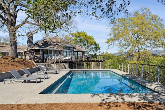 view of swimming pool featuring a deck, stairway, a patio area, and a fenced in pool