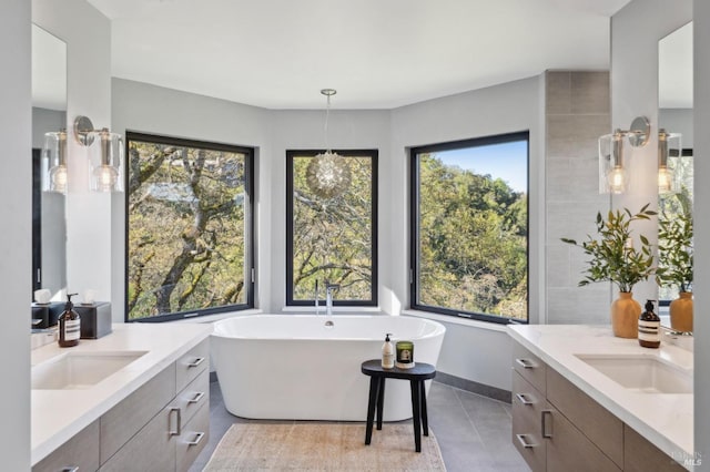 full bathroom with a freestanding tub, two vanities, and a sink