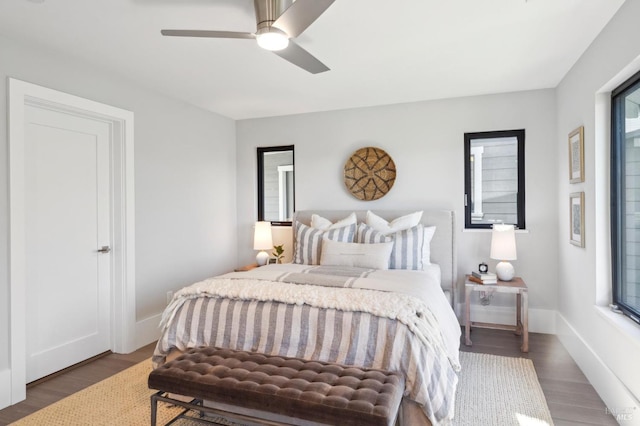 bedroom with ceiling fan, baseboards, and wood finished floors