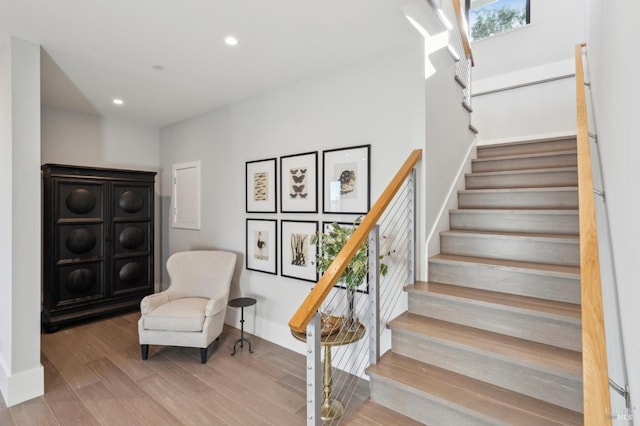 stairs with recessed lighting, baseboards, and wood finished floors