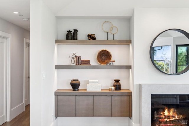 room details featuring recessed lighting, a lit fireplace, and wood finished floors