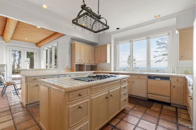 kitchen with paneled dishwasher, a kitchen island, gas cooktop, and a healthy amount of sunlight