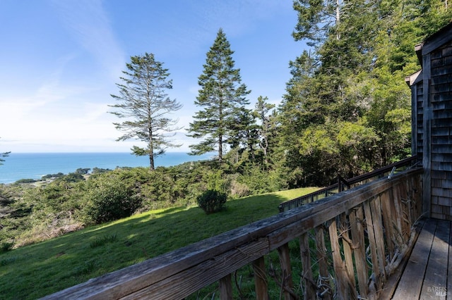 wooden terrace with a water view and a lawn