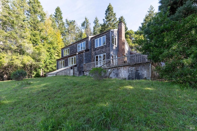 back of property featuring a lawn and a chimney