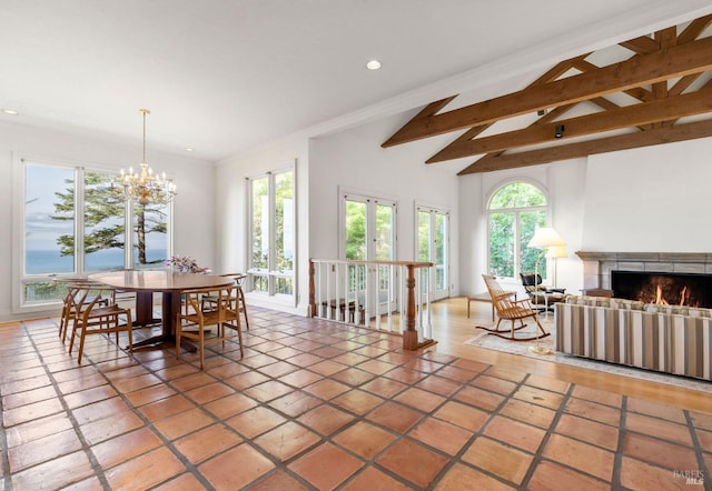 dining room with an inviting chandelier, recessed lighting, vaulted ceiling with beams, and a lit fireplace