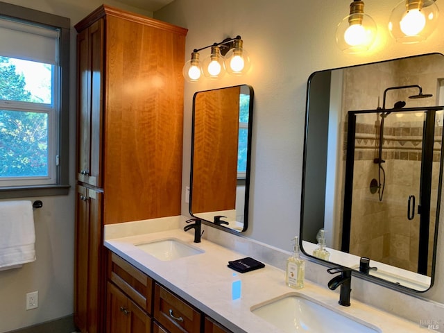 bathroom with a sink, a stall shower, and double vanity