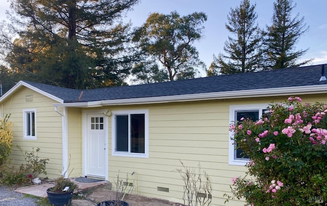 exterior space featuring roof with shingles and crawl space