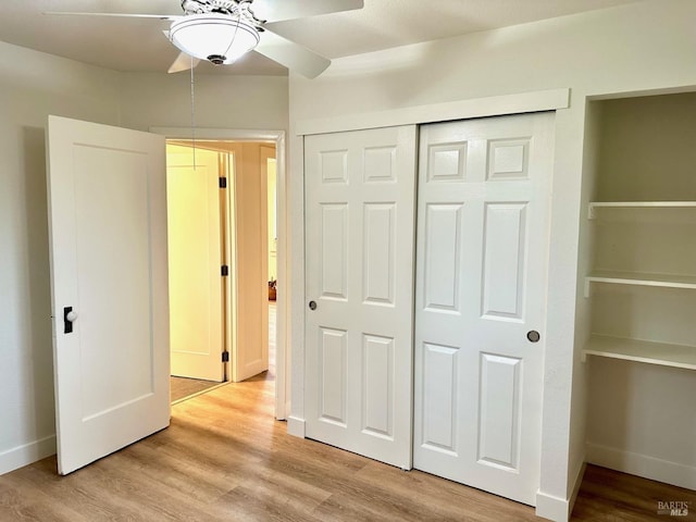 unfurnished bedroom with a closet, light wood-style flooring, and baseboards