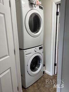 clothes washing area featuring laundry area and stacked washing maching and dryer