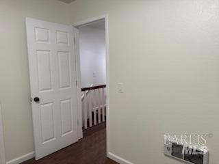 hallway with baseboards and dark wood-style flooring