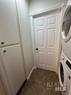 laundry area featuring stacked washer / dryer and laundry area