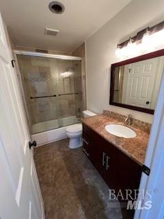 full bathroom with vanity, toilet, and a shower with shower door