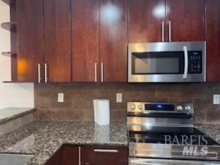 kitchen with backsplash, stone countertops, and appliances with stainless steel finishes