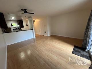 unfurnished living room featuring wood finished floors and a ceiling fan
