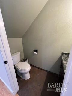 bathroom featuring lofted ceiling and toilet