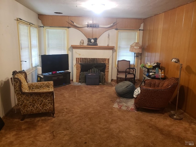 living area with wooden walls, a fireplace, and carpet